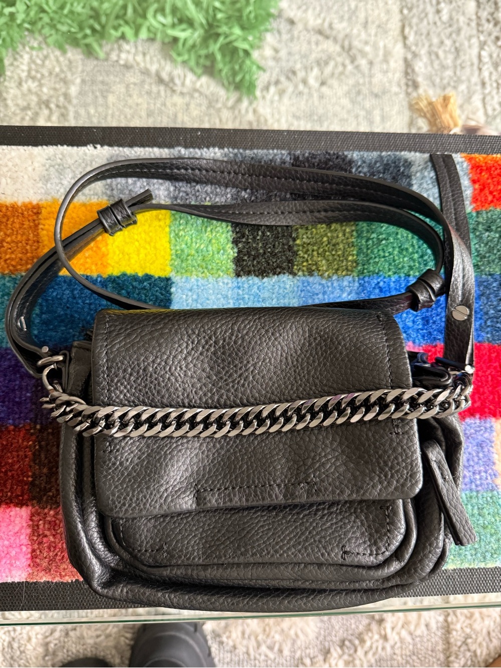 Zara black leather mini crossbody bag with a metallic chain detail.